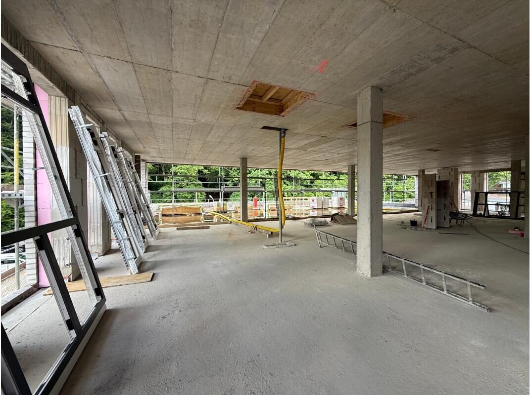 Etage im Rohbau mit Fensterfronten und bereitstehenden Fensterelementen