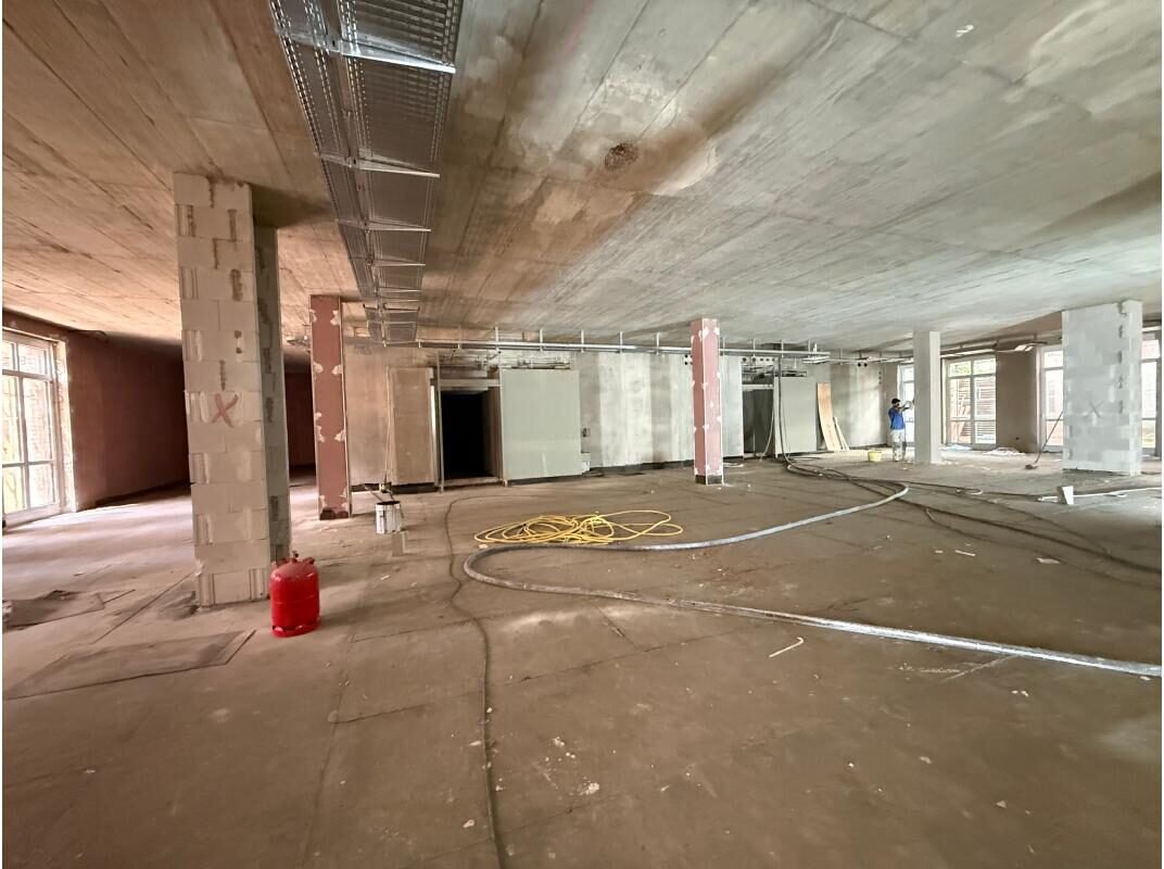 Offene Etage im Rohbau mit Betonstützen und laufendem Innenausbau